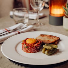 A plate of steak hache sits upon an elegant table