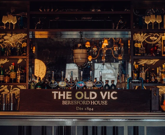 A bar with THE OLD VIC logo displayed, warm lighting, and a range of beer taps