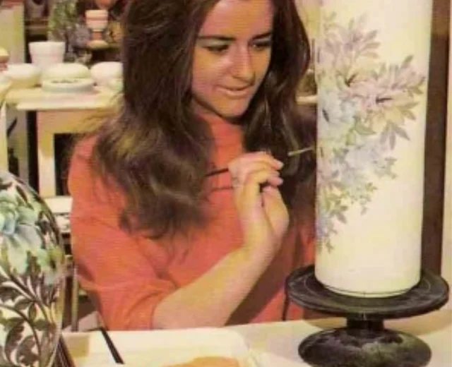 A young lady paints a vase at Jersey Pottery in the 1970s