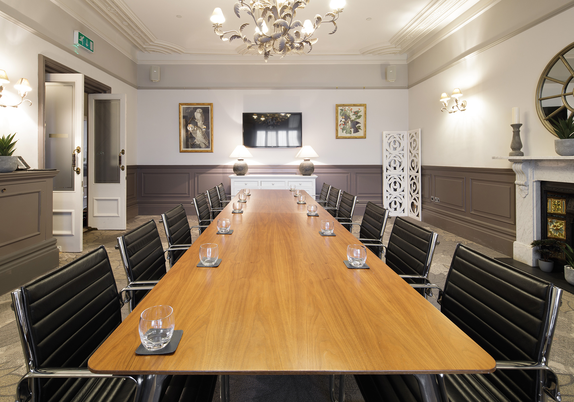 A boardroom with a large wooden board table and leather seats