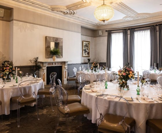 A beautiful private room with elegant Victorian ceiling mouldings, decorated and set for a private event
