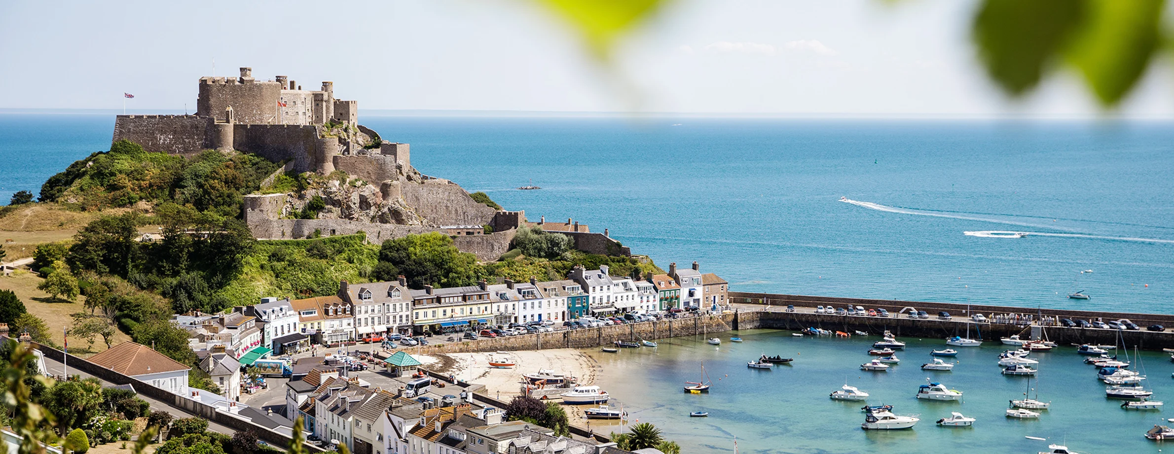 A panoramic view of Mont Orgueil Castle in Gorey, showing the harbour and fields in the foreground