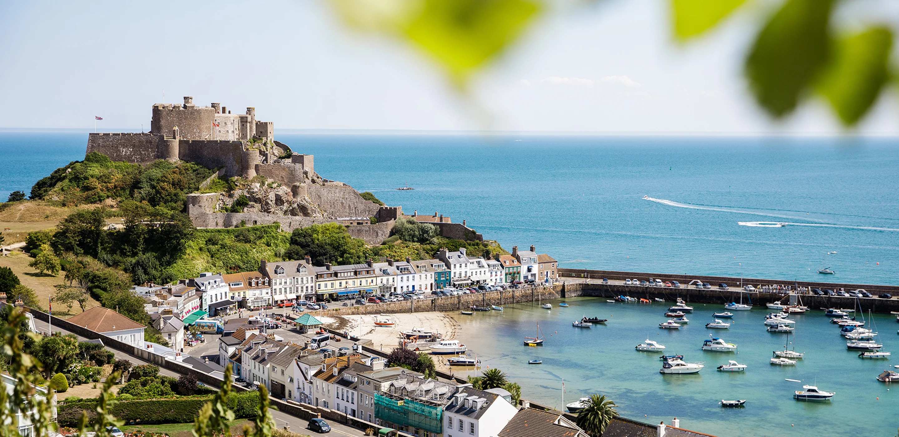 A panoramic view of Mont Orgueil Castle in Gorey, showing the harbour and fields in the foreground