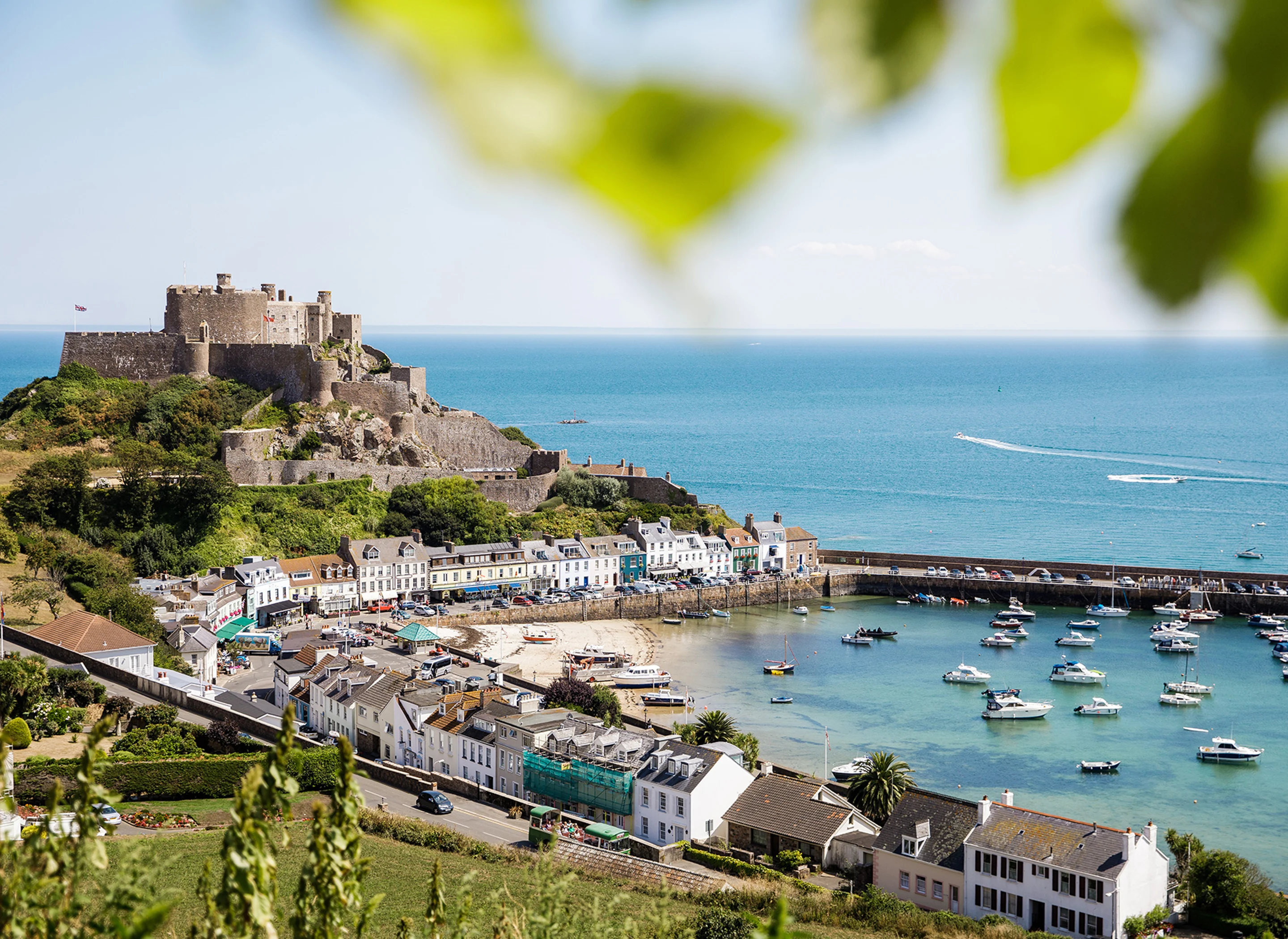 A panoramic view of Mont Orgueil Castle in Gorey, showing the harbour and fields in the foreground