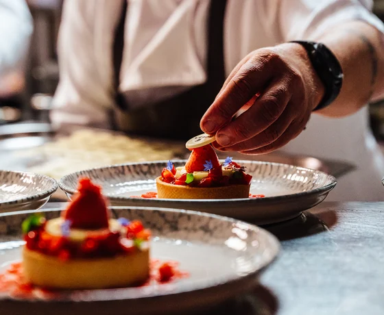 A chef plates an event dessert