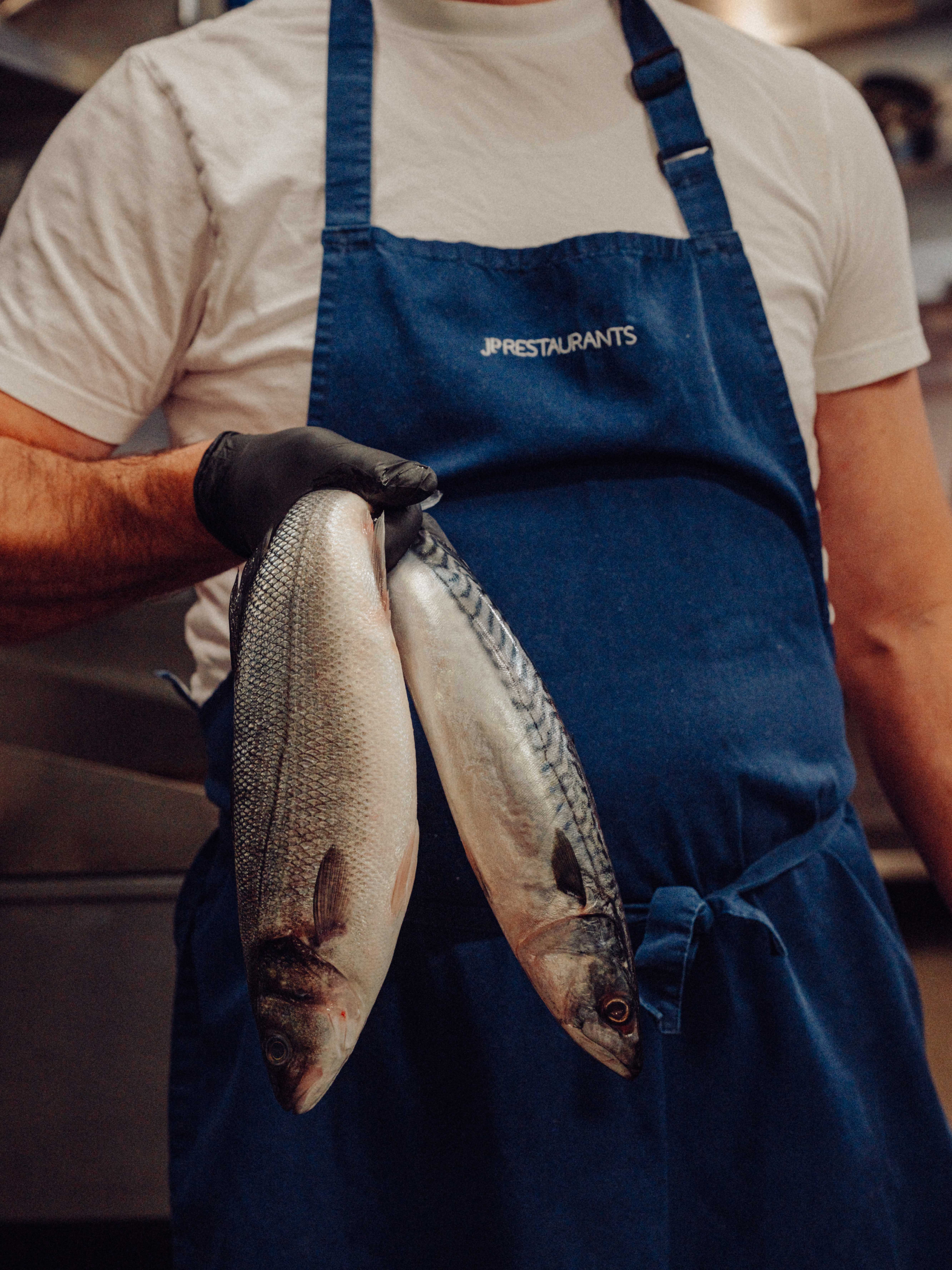 A team member holds up two fresh fish