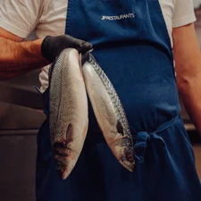 A team member holds up two fresh fish