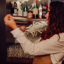 A bar tender prepares a cocktail