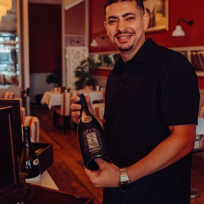 A team member shows a bottle of wine