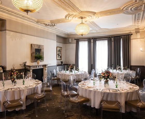 A beautiful private room with elegant Victorian ceiling mouldings, decorated and set for a private event