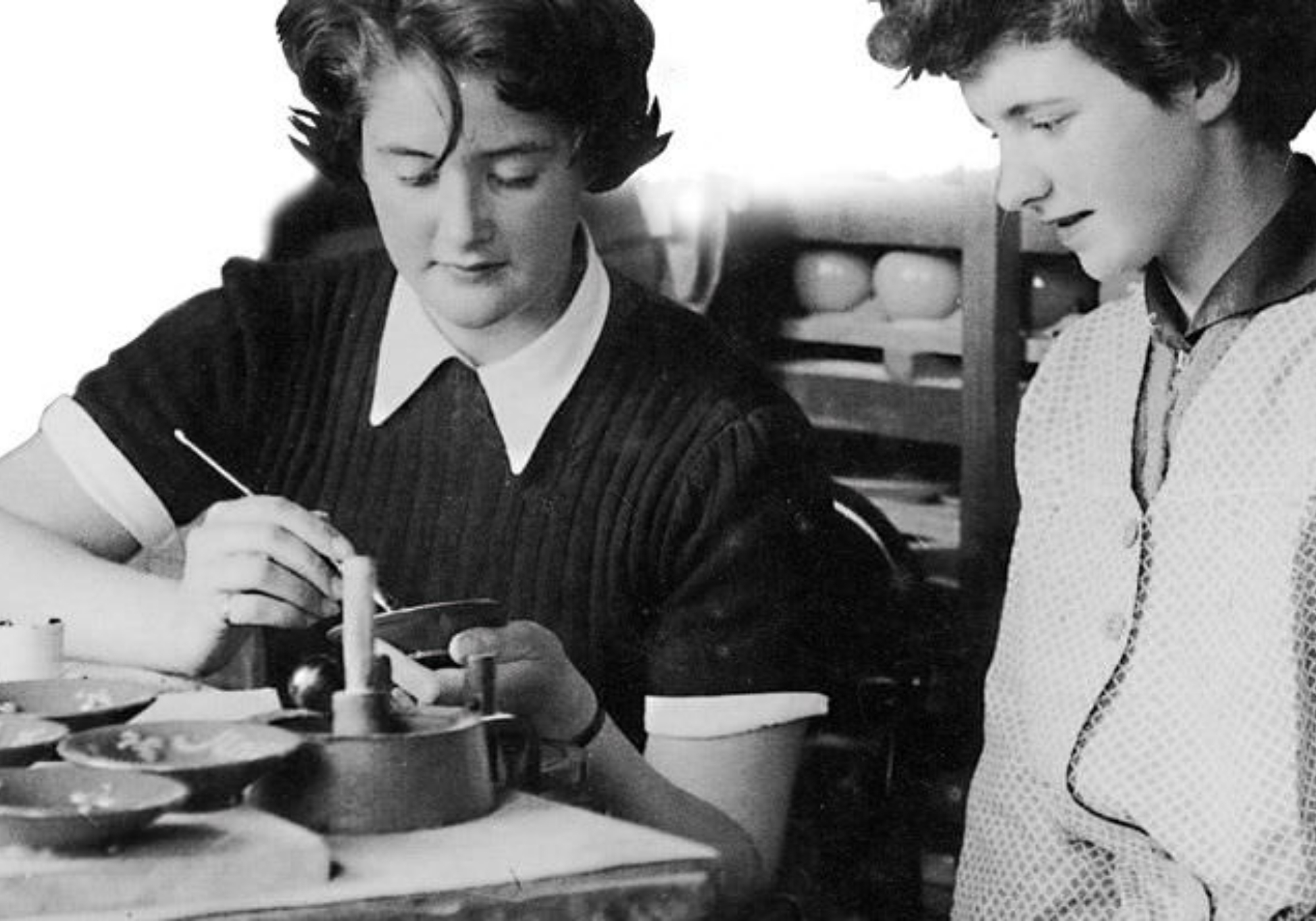 Team members paint pottery in the 1950s