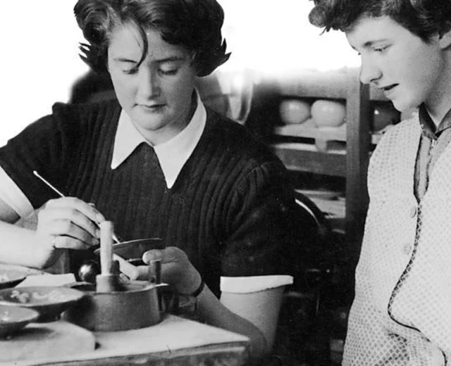Team members paint pottery in the 1950s