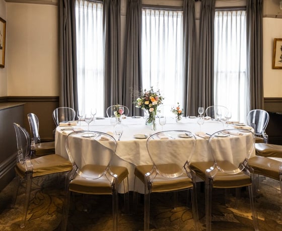 A beautiful private room with elegant Victorian ceiling mouldings, decorated and set for a private event