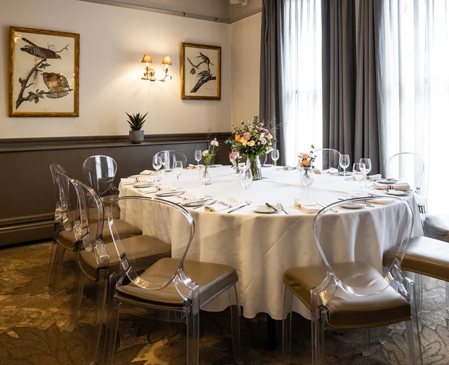 A beautiful private room with elegant Victorian ceiling mouldings, decorated and set for a private event