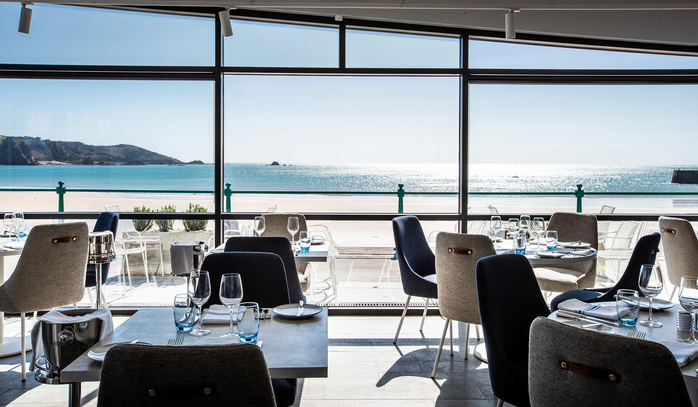 An elegant seaside restaurant interior, including sweeping views over the beach