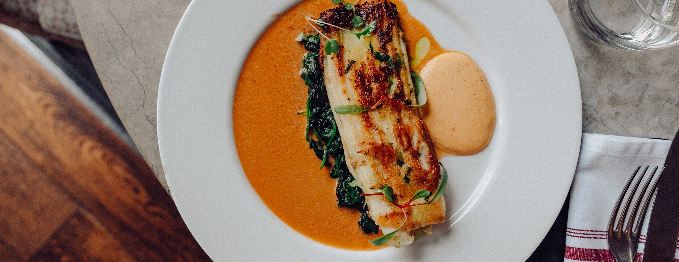 A fillet of fish presented simply on an elegant brasserie plate