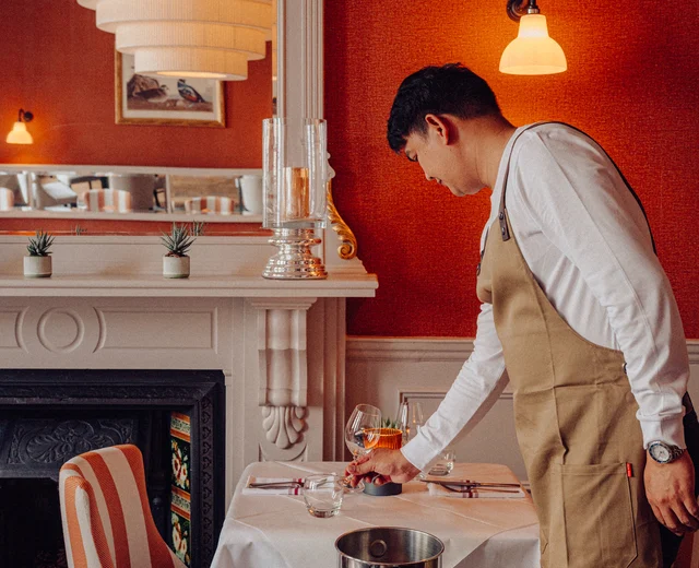 A team member sets a table at Beresford House