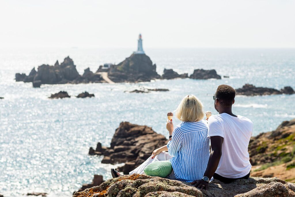 A couple enjoy ice cream in front of Corbiere Lighthouse