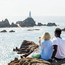 A couple enjoy ice cream in front of Corbiere Lighthouse