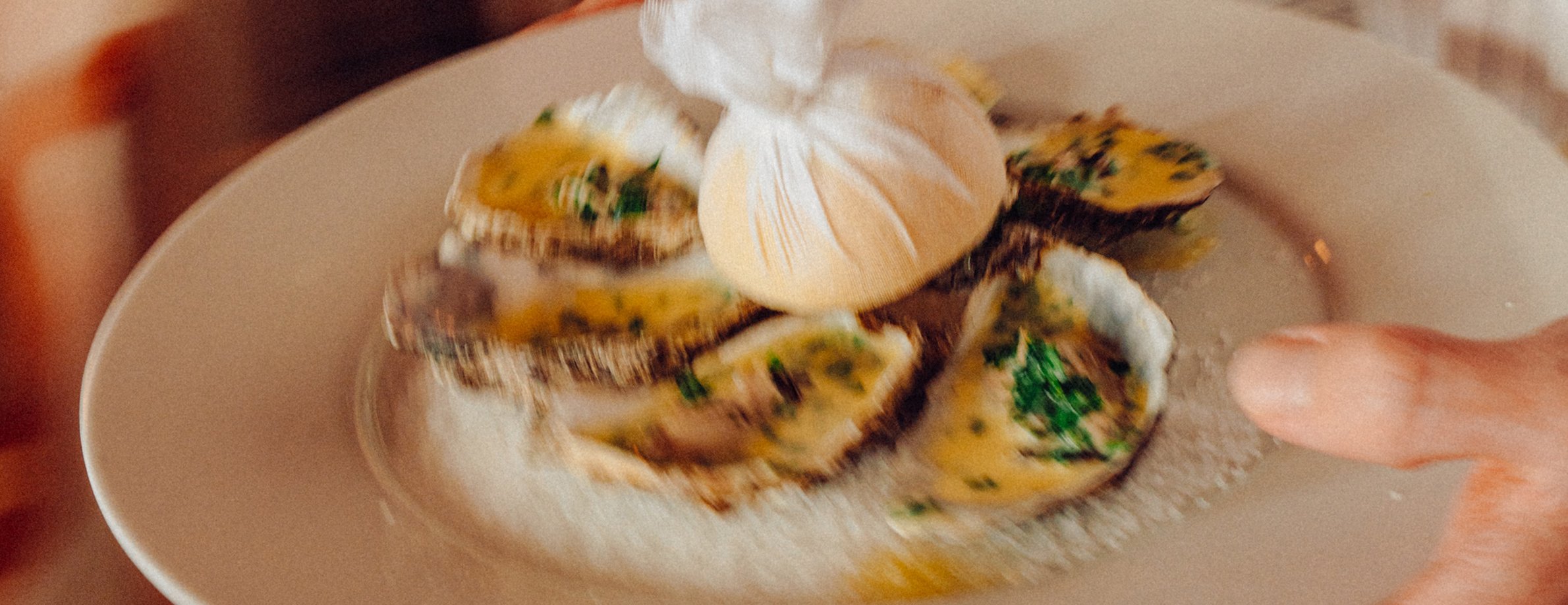 A server carries a plate of oysters into Beresford House Dining Room