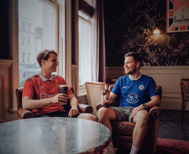 Two males in their early 30s watch football at The Old Vic