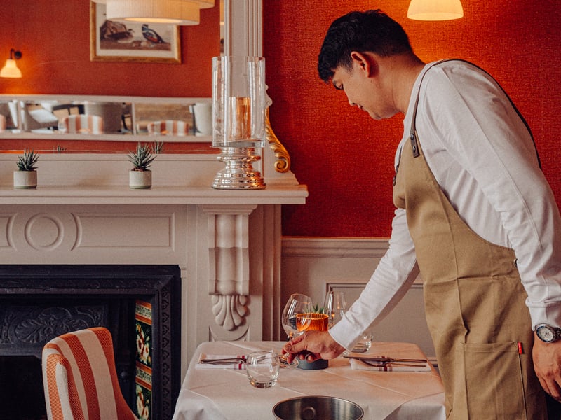 A server prepares the table at Beresford House