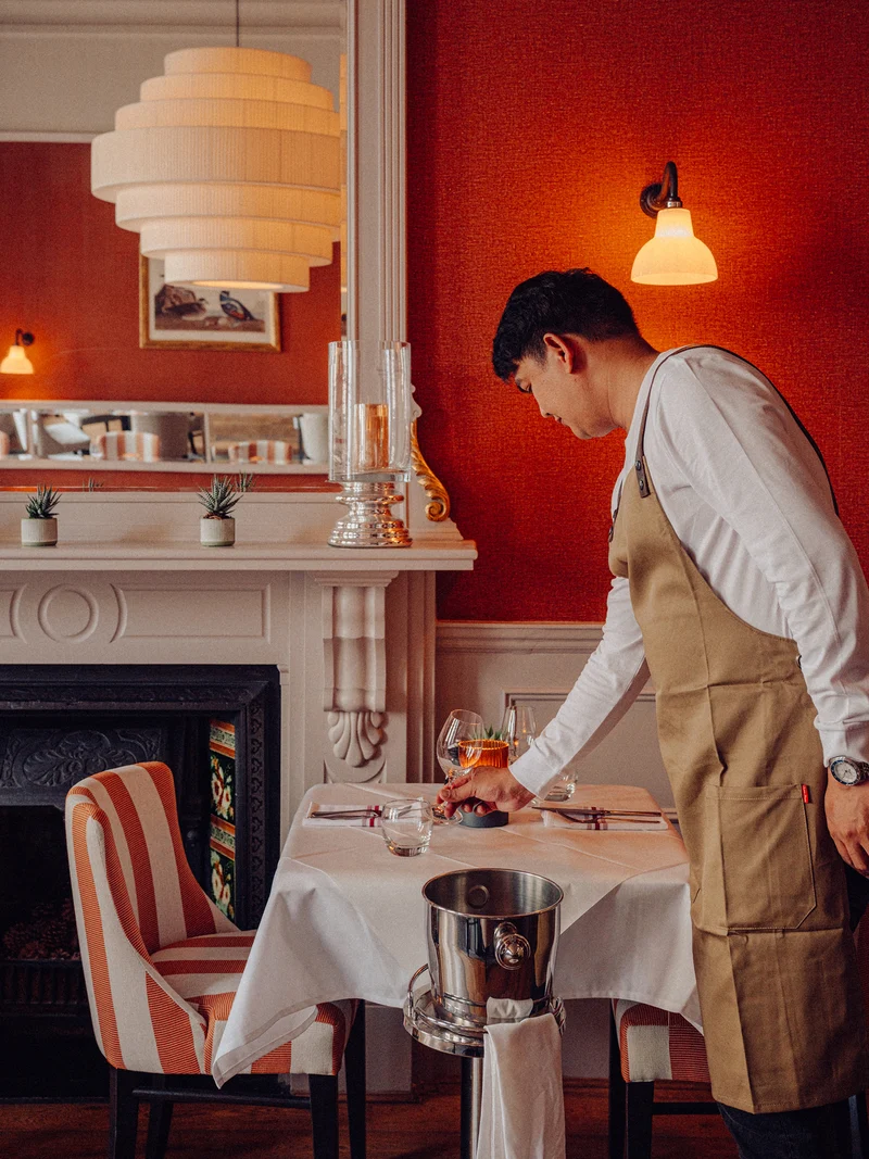 A server prepares the table at Beresford House
