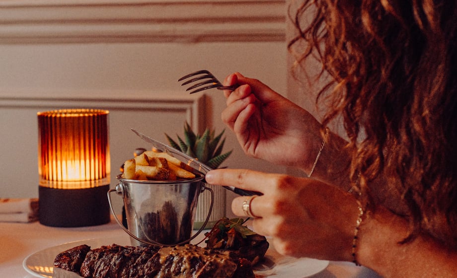 A guest enjoys a plate of steak
