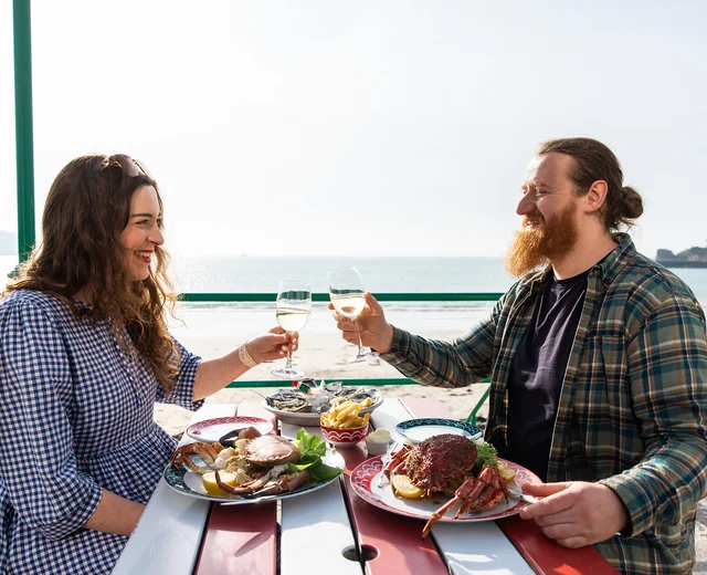 Guests toast on the terrace while eating fresh crab
