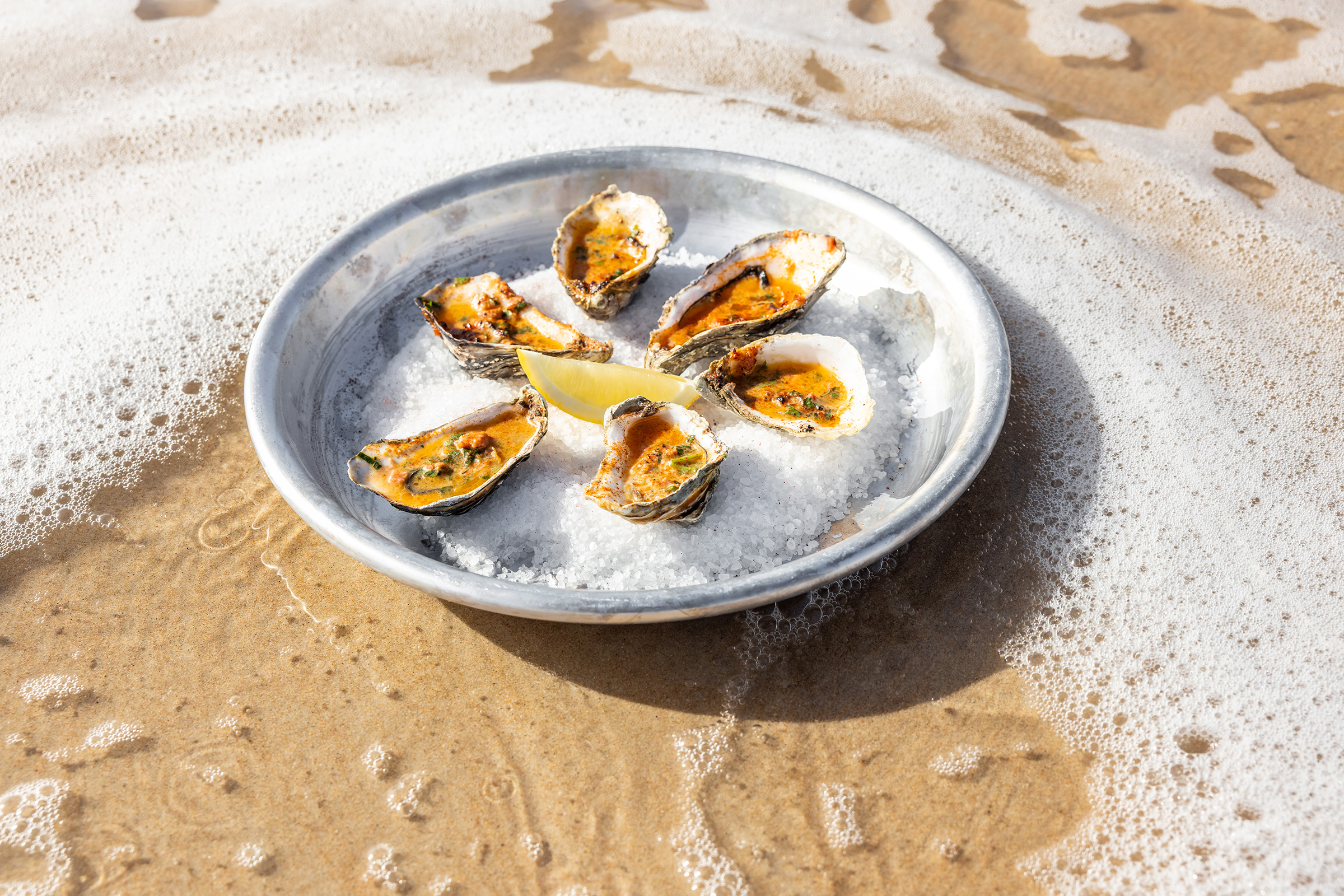 A plate of chorizo oysters, photographed in the shallow waters of St Brelade's Bay