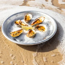 A plate of chorizo oysters, photographed in the shallow waters of St Brelade's Bay