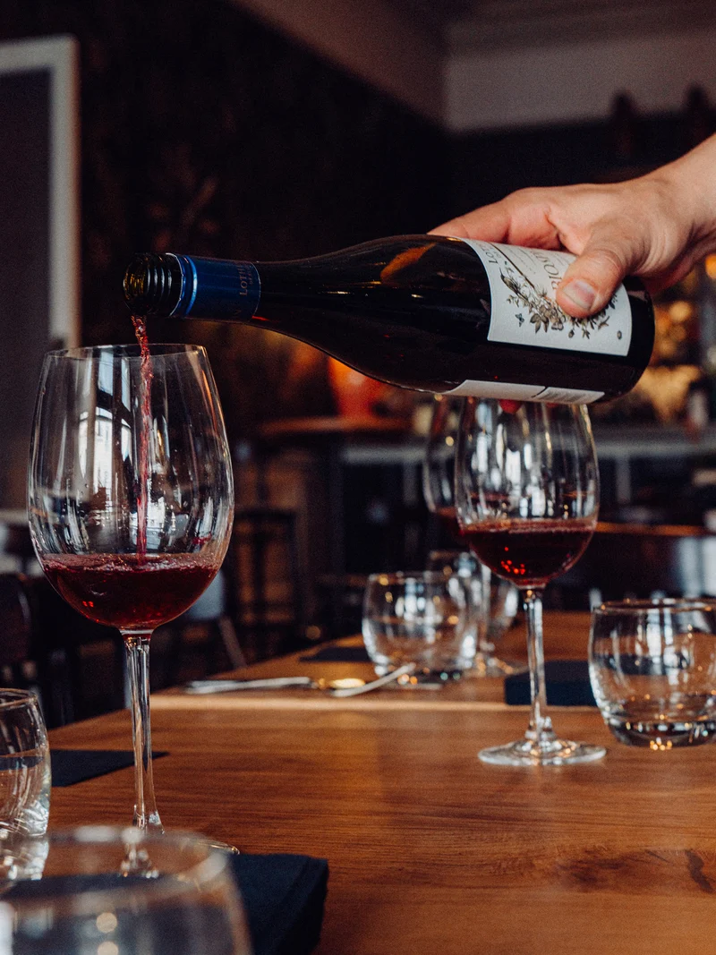 A team member pours wine in The Old Vic