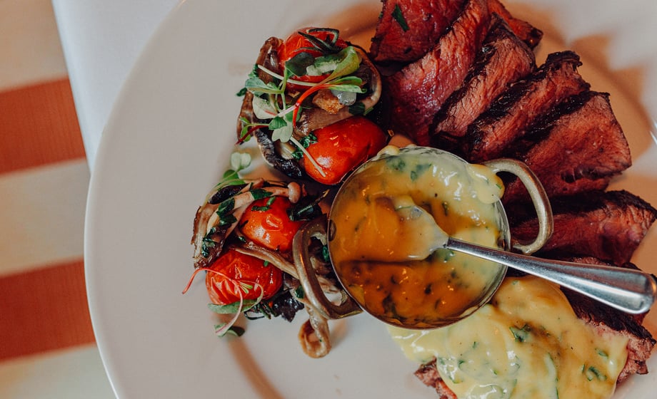 A steak serve with sauce and tomatoes