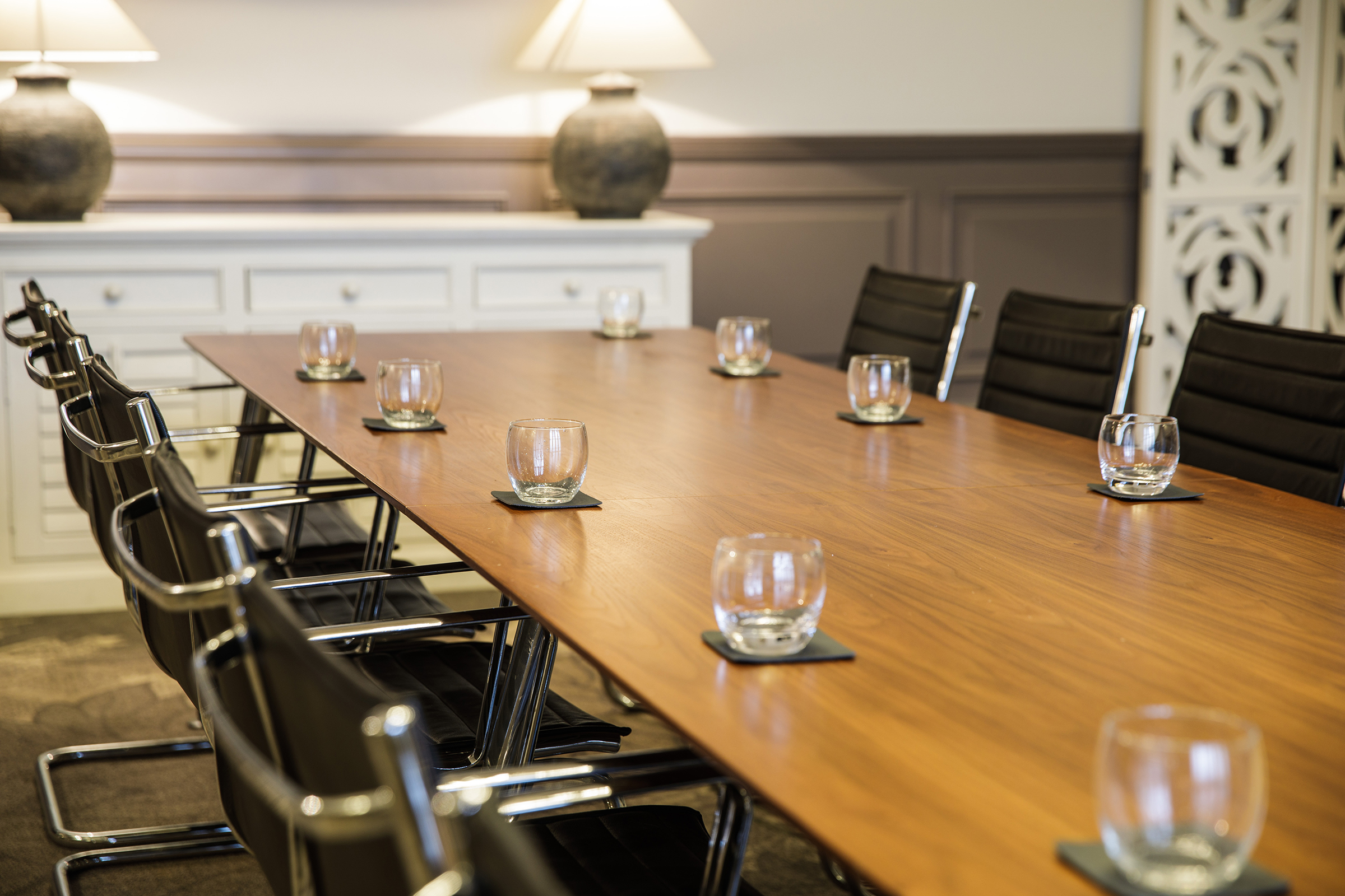 A close-up of a boardroom table, set up for a meeting